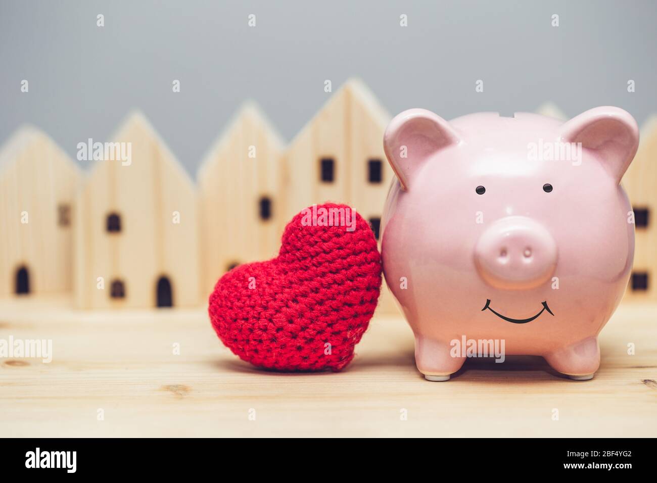 Sorriso carino maiale con cuore rosso sullo sfondo del villaggio per amore comunità concetto casa sicuro. Foto Stock