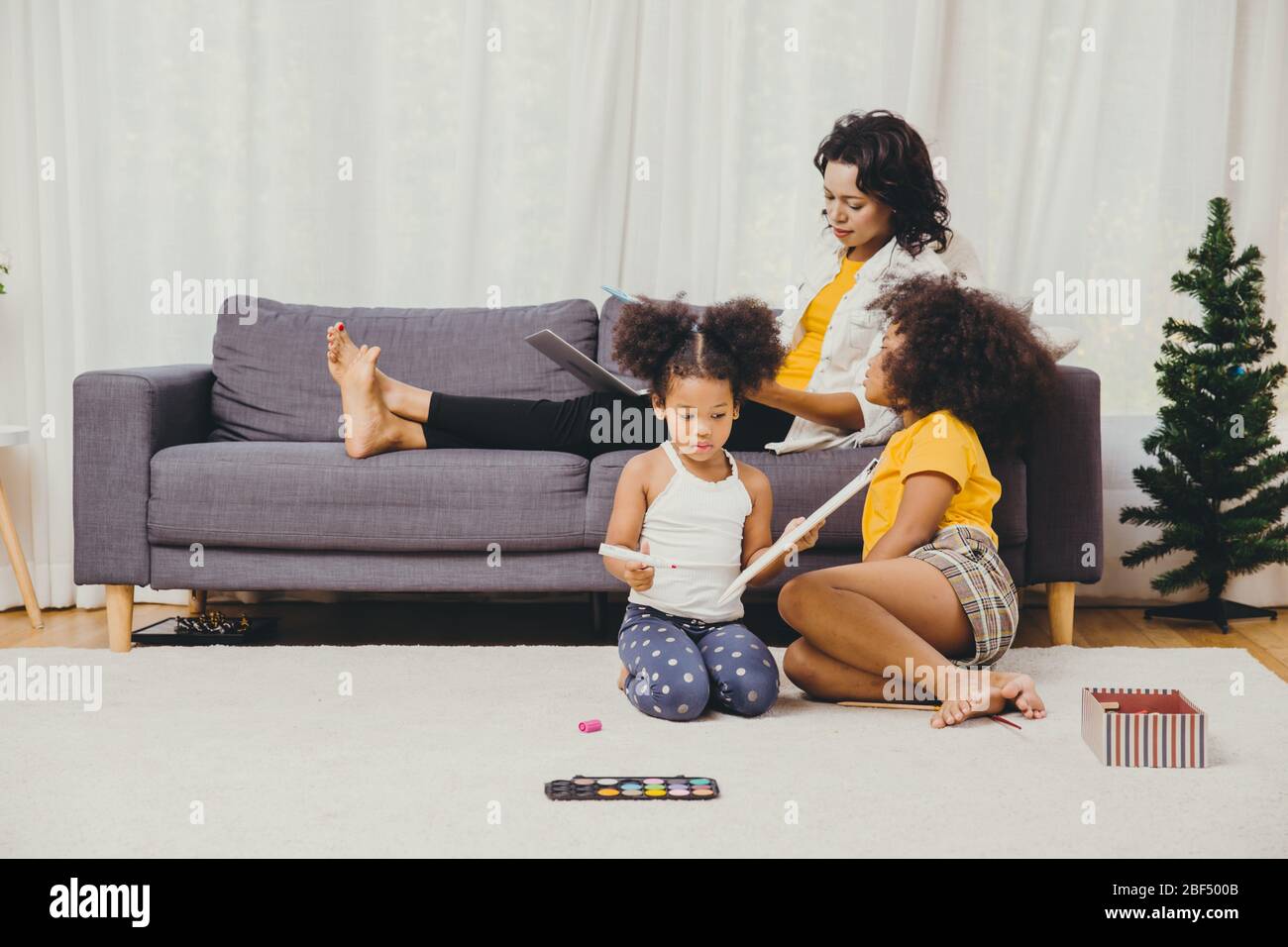 Il lavoro del genitore a casa da computer portatile del Internet effetto di covid-19 malattia pandemica del virus madre sana felice di vivere per rimanere e giocare con il suo chil Foto Stock