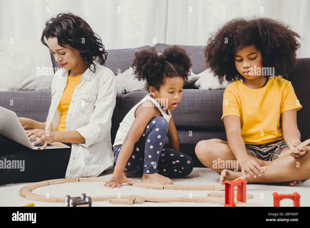 Il lavoro del genitore a casa da computer portatile del Internet effetto di covid-19 malattia pandemica del virus madre sana felice di vivere per rimanere e giocare con il suo chil Foto Stock