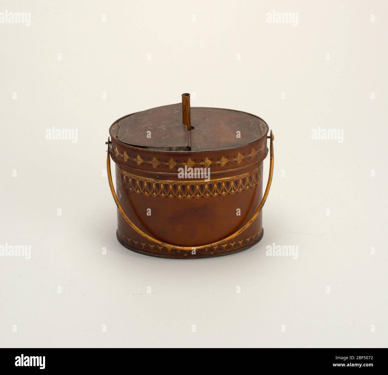 Scaldabuette. In pianta ovale verniciato, con grande maniglia ad anello imbullonato, coperchio incernierato a due lacciature. Macinato marrone con fascia di rotoli di foglie dorate. Foto Stock