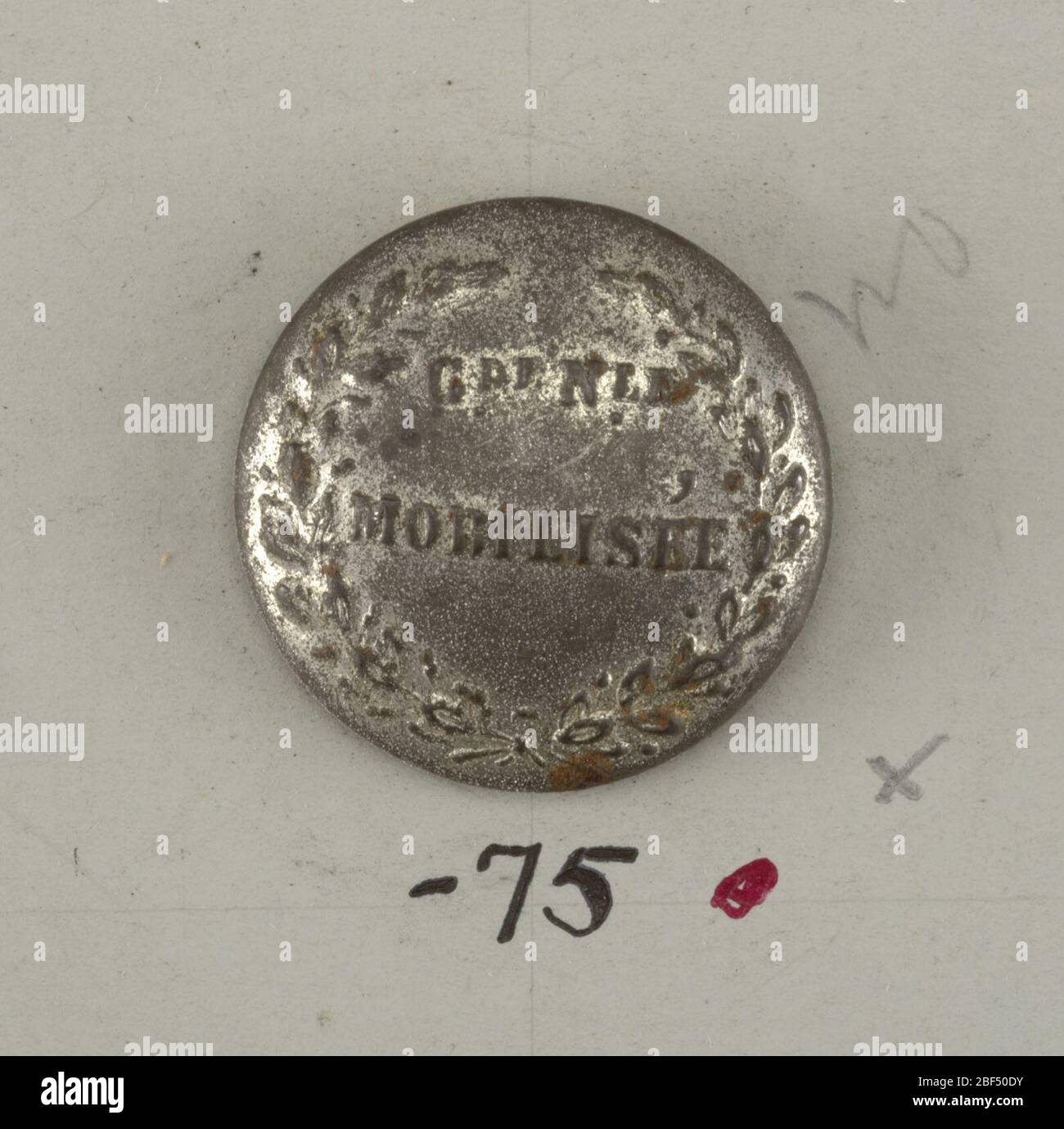 Pulsante. Pulsante leggermente convesso con 'Grelle Mobilizee' collocato all'interno di spruzzi di alloro incrociati.sulla scheda D. Foto Stock