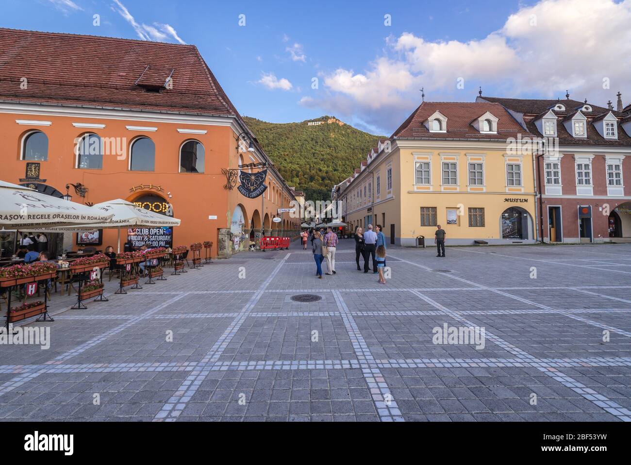 Edifici su Piata Sfatului - Piazza del Consiglio a Brasov, il centro amministrativo della contea di Brasov, Romania, vista con Tampa montagna sullo sfondo Foto Stock