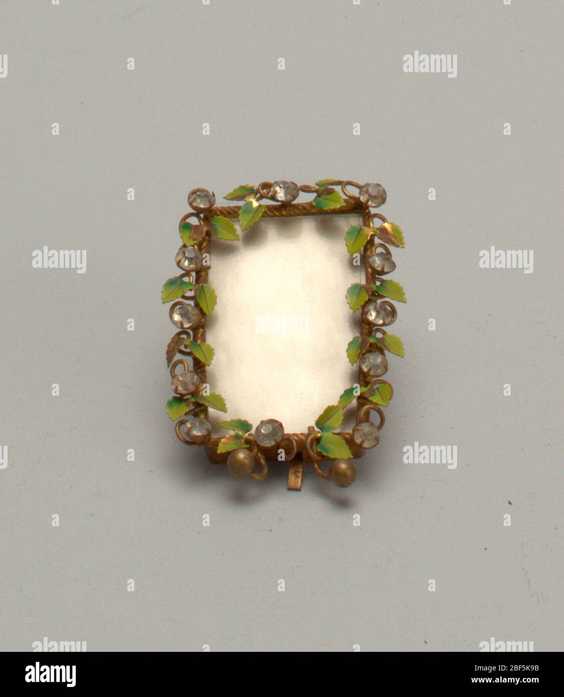 Telaio. Rettangolo verticale di ottone, con foglie con gambo verniciato verde, e dodici 'diamonds' di vetro posti in rebbi. Sfere di ottone piccole per i piedi. Lamiera di stagno per retro con asta di ottone per supporto. Foto Stock