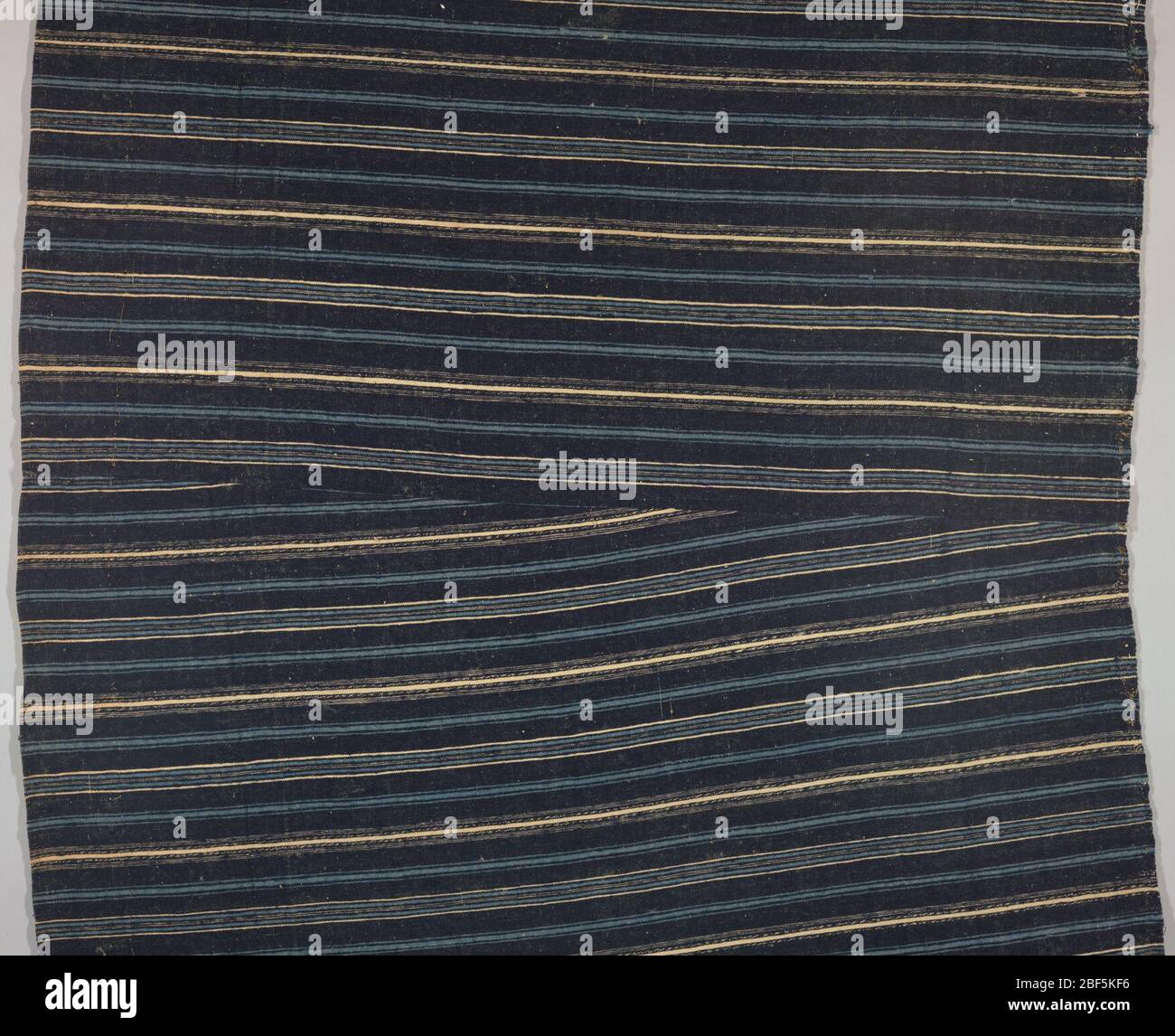 Frammento di bordo. Frammento di un pannello di gonna a strisce di blu scuro, blu chiaro e bianco. Foto Stock