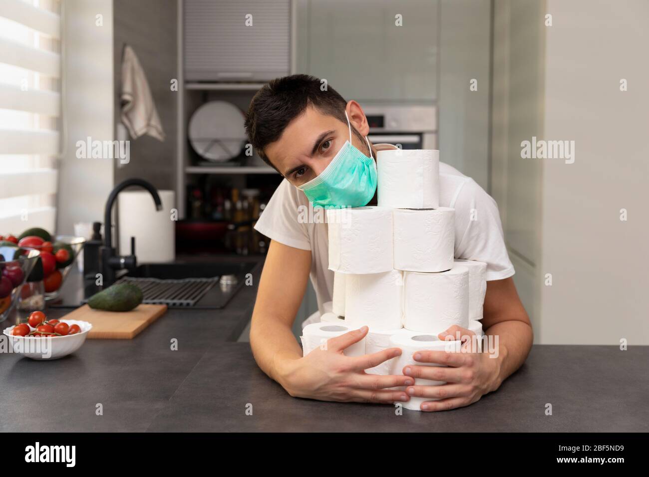 Un uomo gioisce sulla carta igienica acquisita a causa del panico e della carenza causati dallo scoppio del virus covid19. Foto concettuale su Foto Stock