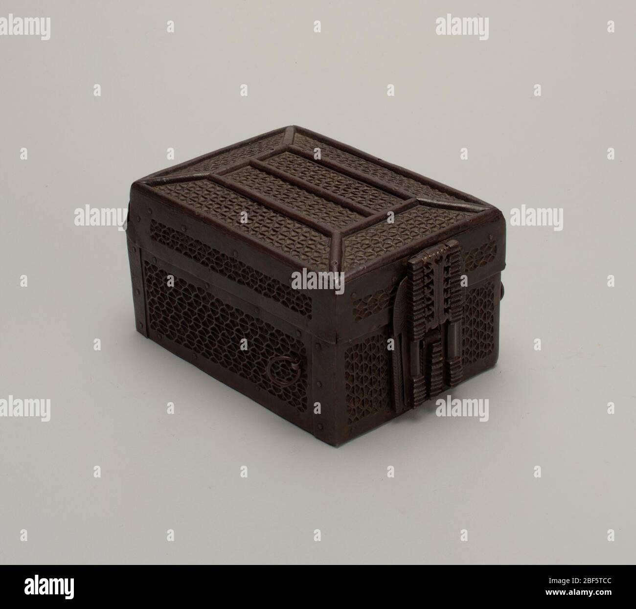 Scatola. Rettangolare, con coperchio a cupola piatta e incernierato; legno, rivestito con due spessori di lamiera di ferro perforata in file parallele di ripetizioni di motivi di trafilatura, i bordi feriscono su filo semicirpino; ad un'estremità, elaborato blocco di ferro con lunga naspo; su ciascuno dei più larghi s. Foto Stock