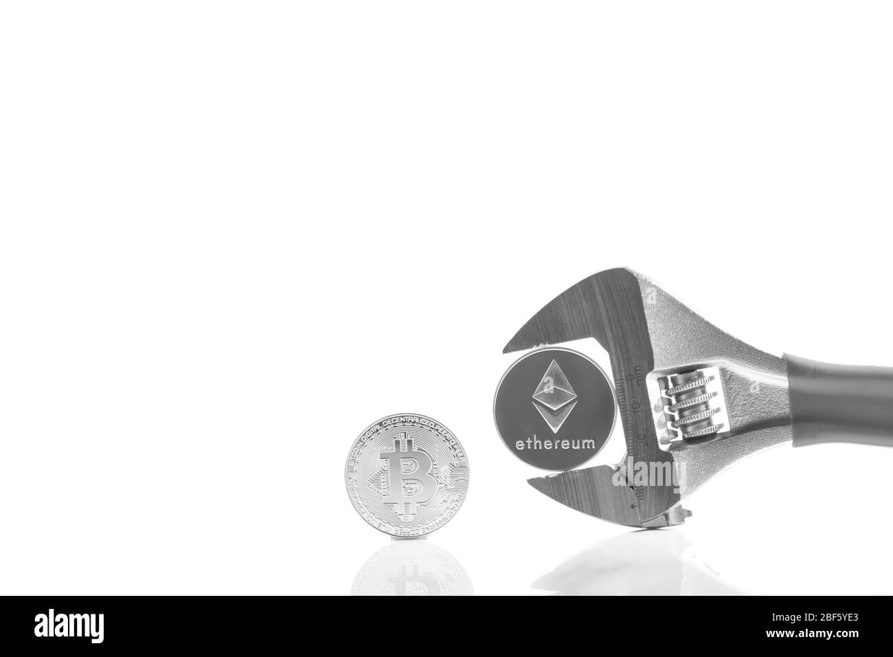 Criptovaluta sulla scrivania riflettente, primo piano. Denaro virtuale di criptovaluta. Exchange, anonimo. Bitcoin è una valuta di cassa web open source. Bianco Foto Stock