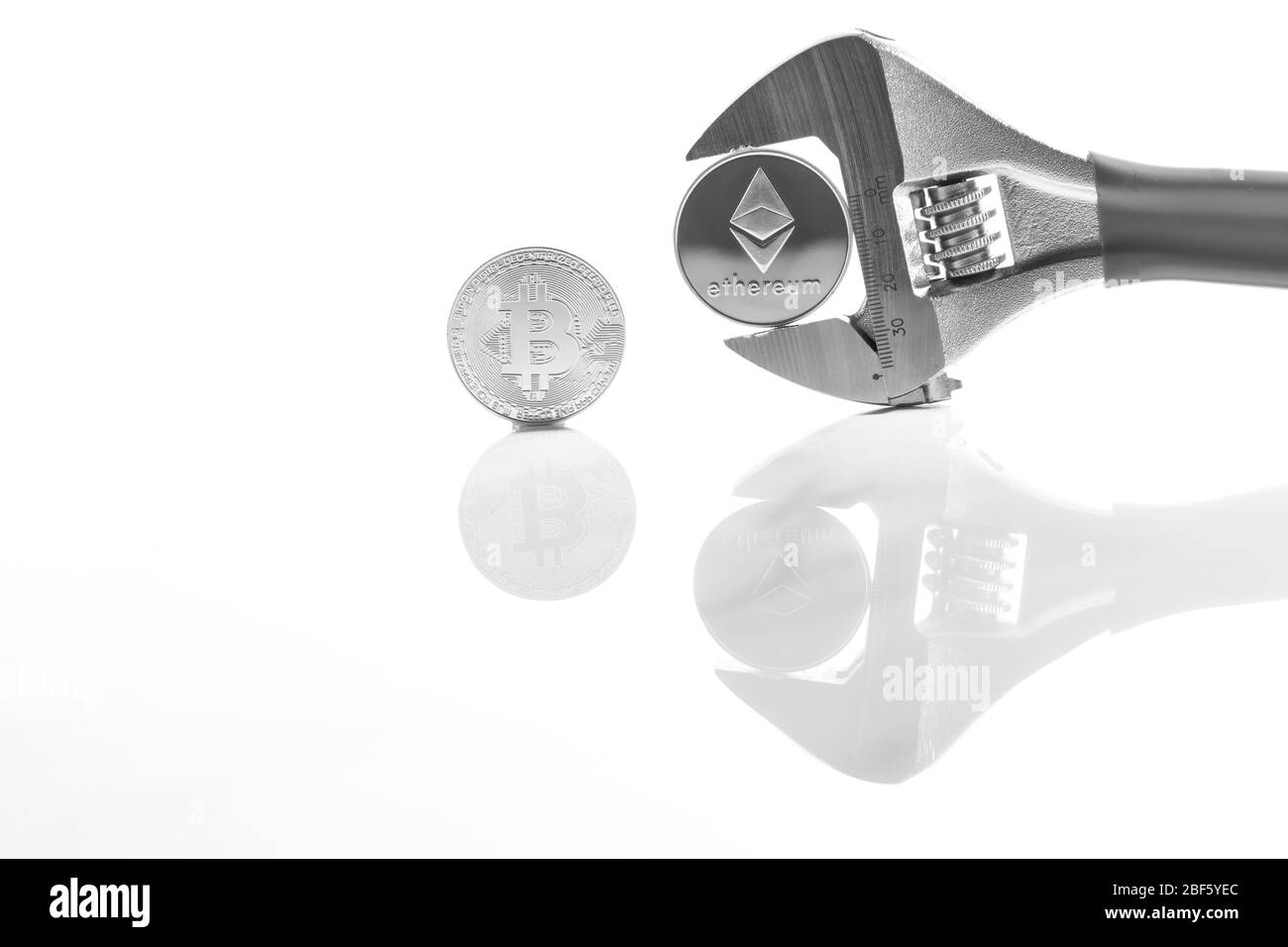 Criptovaluta sulla scrivania riflettente, primo piano. Denaro virtuale di criptovaluta. Exchange, anonimo. Bitcoin è una valuta di cassa web open source. Bianco Foto Stock