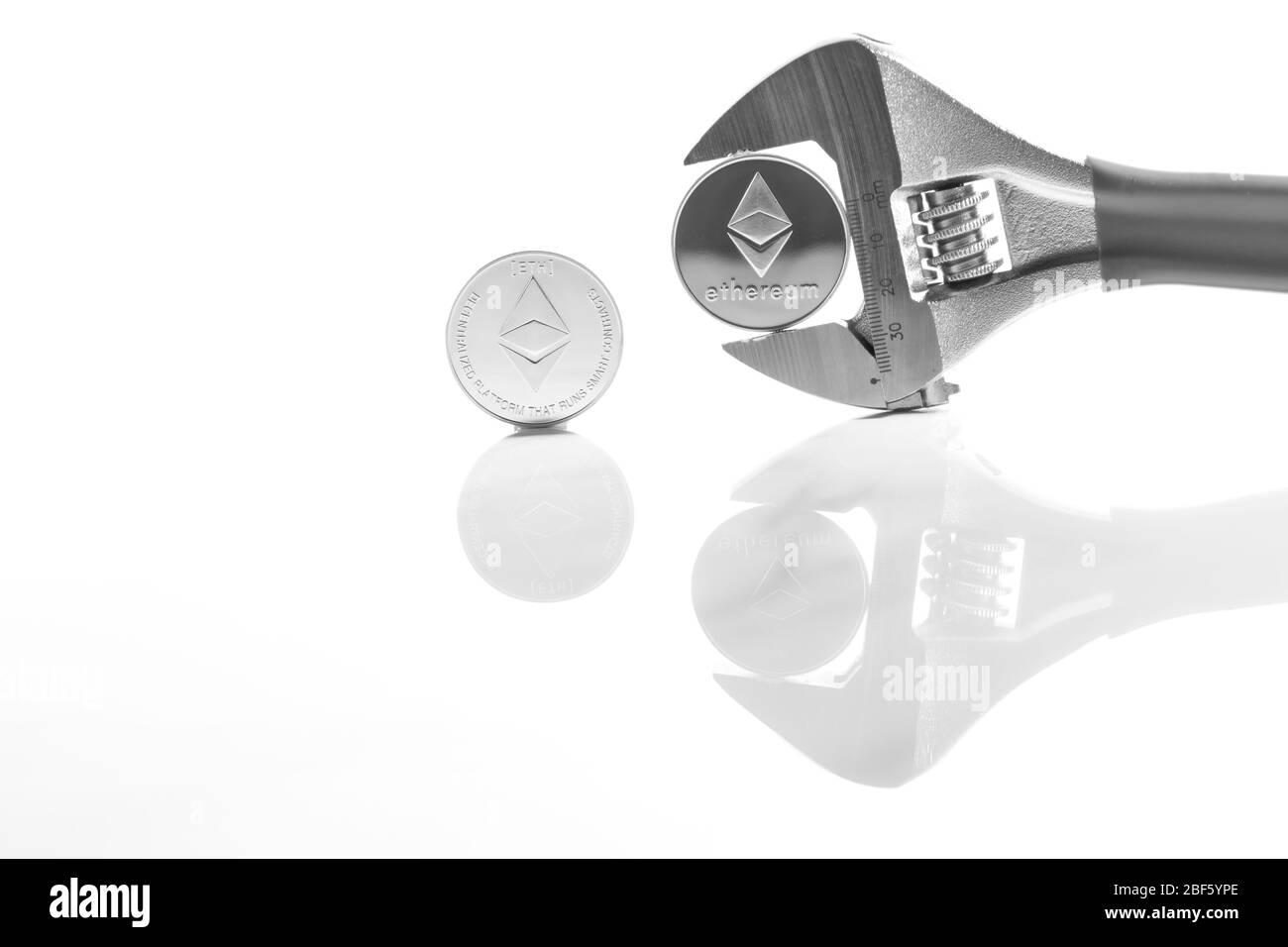 Ethereum sulla scrivania riflettente, primo piano. Denaro virtuale di criptovaluta. Exchange, anonimo. Bitcoin è una valuta di cassa web open source. Bianco retro gr Foto Stock