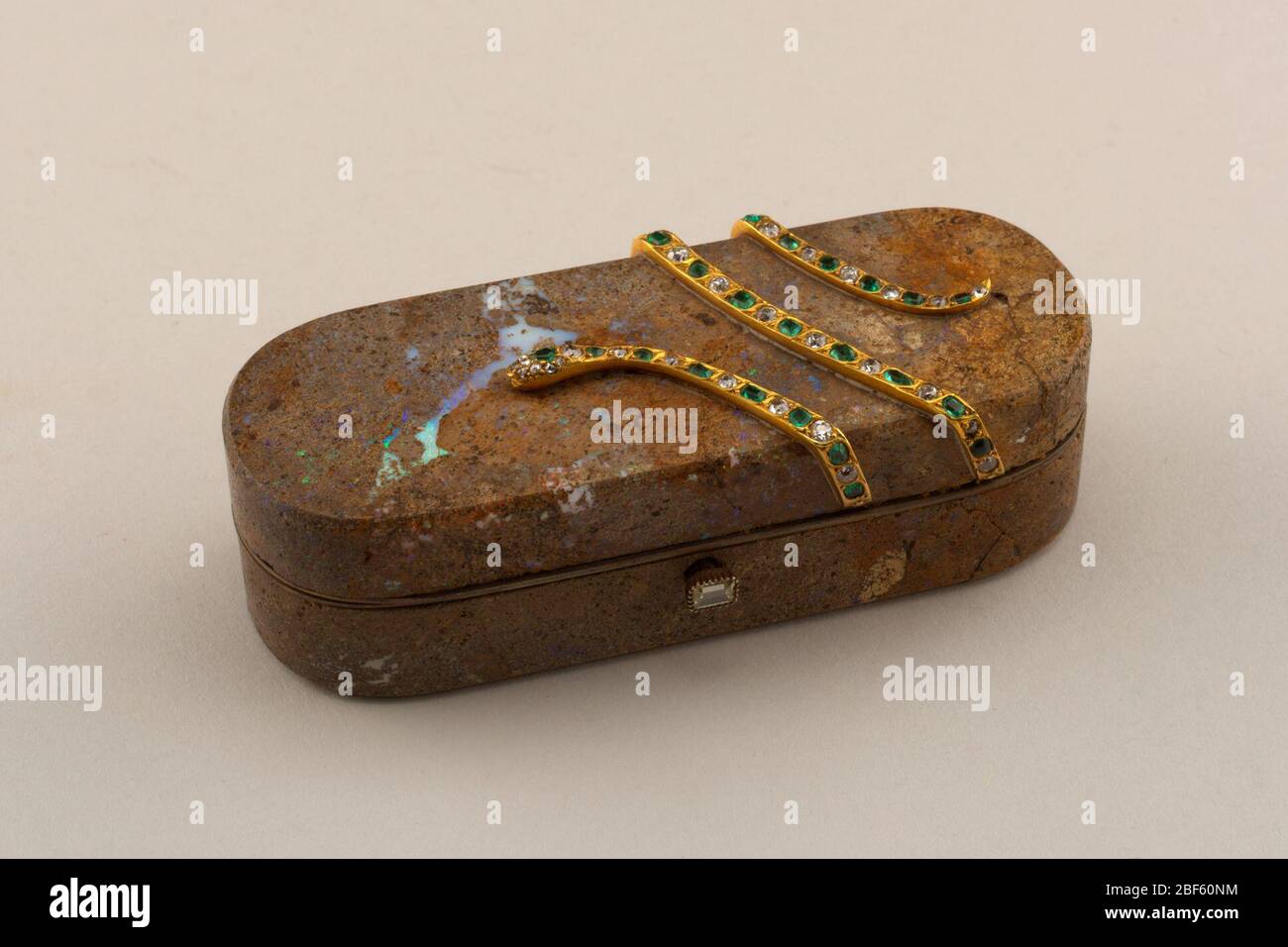 Scatola. Scatola, oblunga con estremità arrotondate; tagliata a matrice opale con serpente d'oro applicato, incastonata con smeraldi e diamanti. Foto Stock