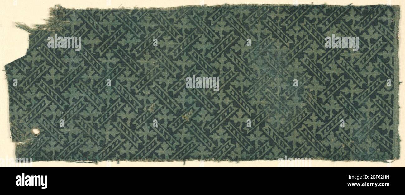 Frammento. Motivo di foglie e barre diagonali blocco stampato in nero (ora sbiadito) su tessuto precedentemente tinto blu-verde. Foto Stock