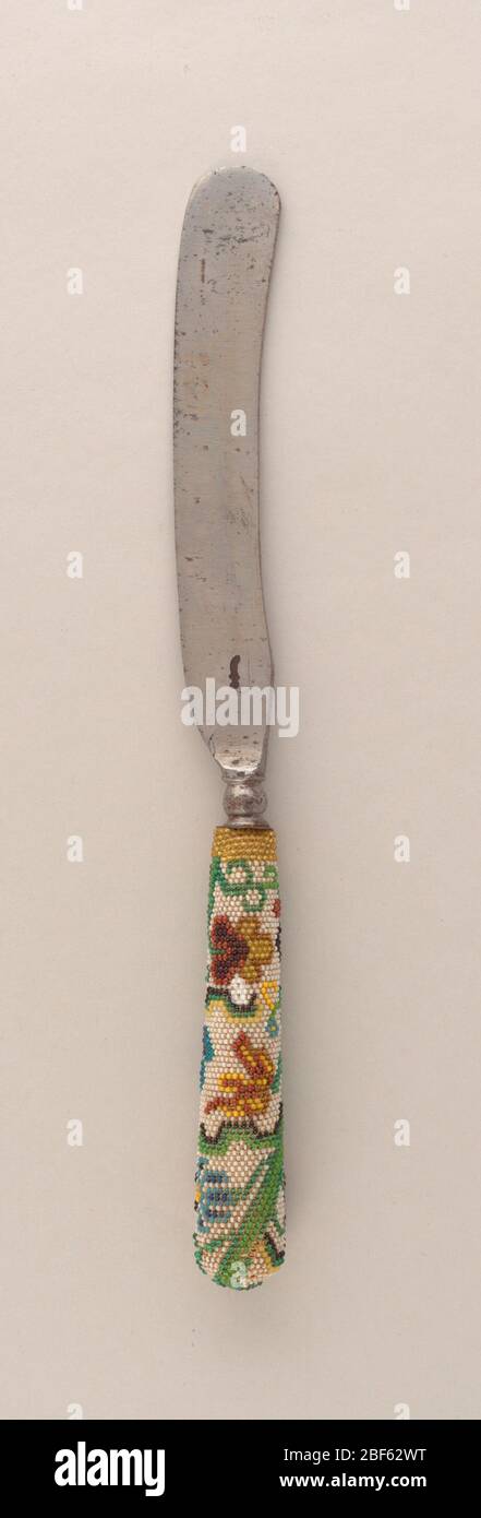 Coltello. Lama a forma di scimitar. Manico affusolato decorato con perline di vetro multicolore; motivo floreale in verde, blu, marrone e giallo su terreno bianco. Foto Stock