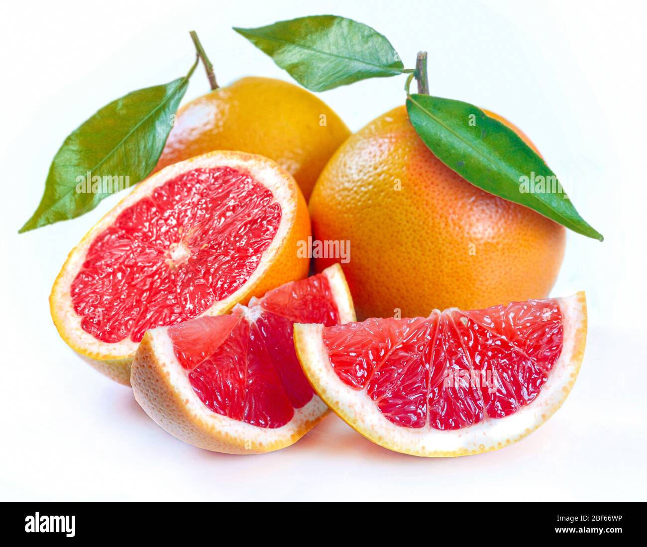Fetta di pompelmo con foglie isolati su sfondo bianco Foto Stock
