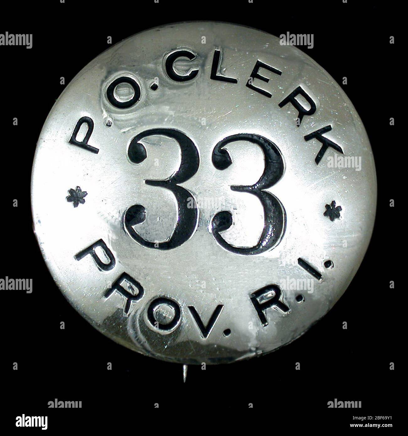 Badge postale torace impiegato numero 33. Badge impiegato del reparto postale degli Stati Uniti, numero 33, con perno incernierato verticale e gancio sul verso. Design rotondo con parte superiore contrassegnata con 'P.O. CLERK' e la parte inferiore sono scritte con 'PROV. R.I.' Cifre numeriche posizionate al centro del badge. Foto Stock