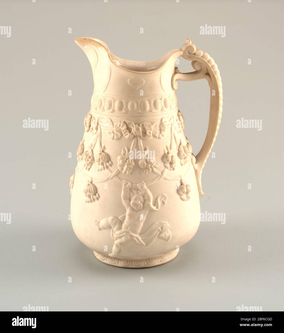 Caraffa Parianware con Garlands di frutta e Putti. Corpo bulbo con decorazione in rilievo che mostra putti appesi a nastri e swags con pendenti da frutta. Uovo e dardo stampaggio circa collo. Cinturino e cabochon sotto un labbro svasato. Maniglia composta da cinghie arrotolate sotto una colonna vertebrale segmentata. Foto Stock