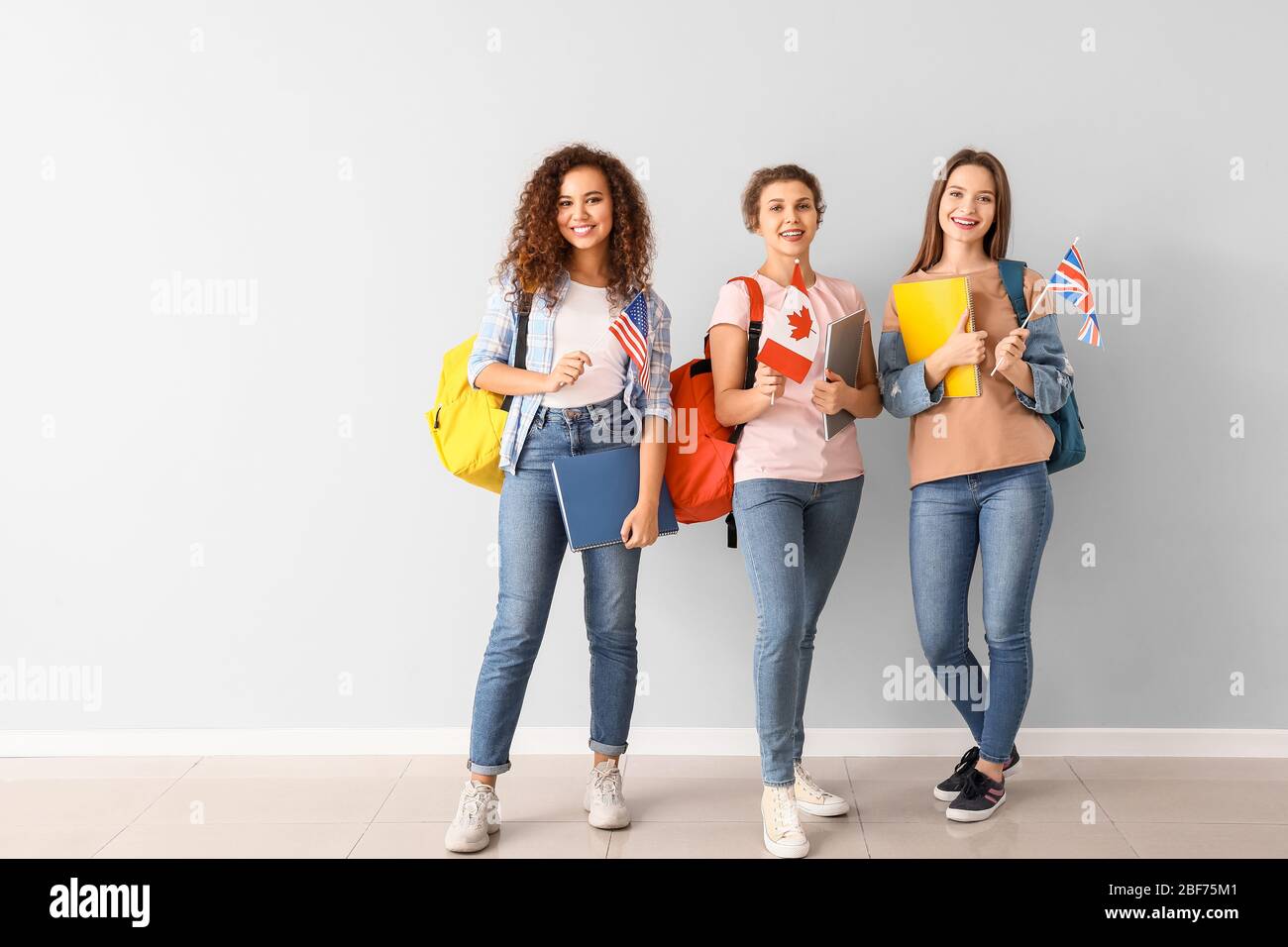 Giovani studenti di scuola di lingua vicino alla parete della luce Foto Stock