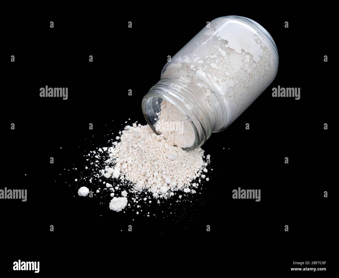 Caolino aka White Cosmetic Clay polvere in bottiglia di vetro, su nero. Bellezza cosmetica. Foto Stock