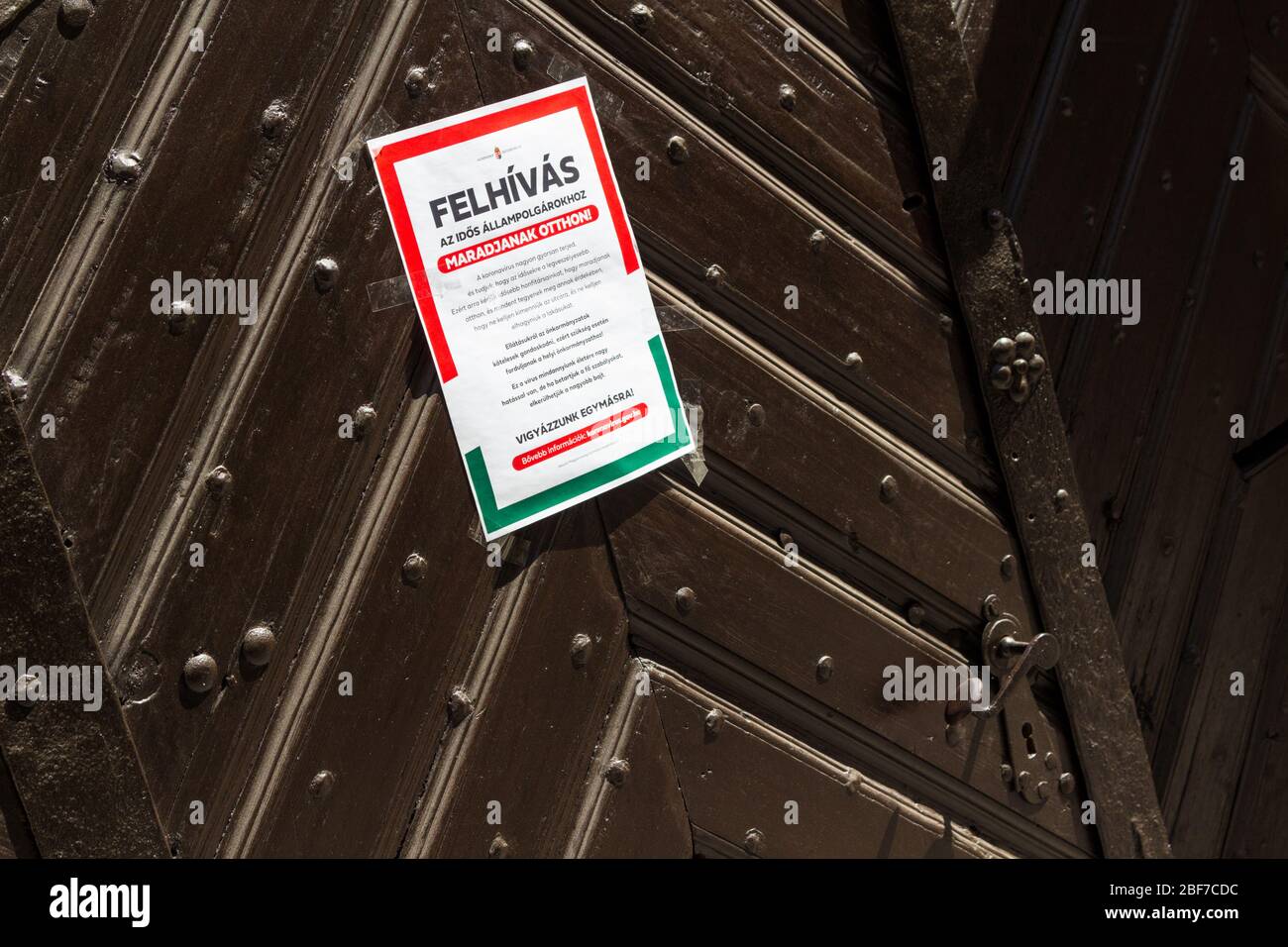 Avvertenza per gli anziani di rimanere a casa durante il blocco del coronavirus appiccicato su ogni porta d'ingresso, Sopron, Ungheria Foto Stock