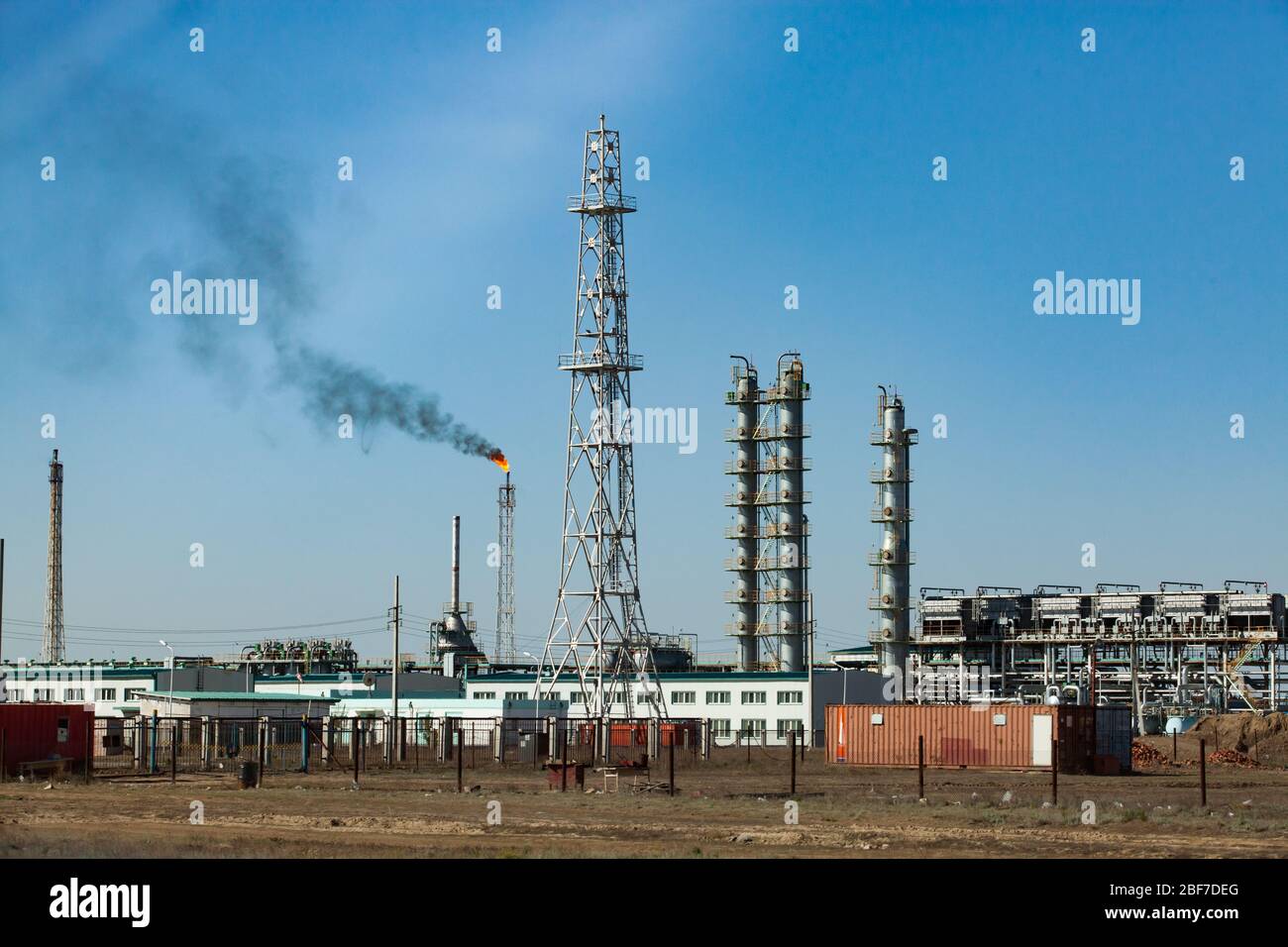 Raffineria di petrolio e impianto di lavorazione del gas. Vista della torre di comunicazione, delle colonne di raffinazione, del palo per torcia a gas, delle tubazioni e degli edifici industriali Foto Stock