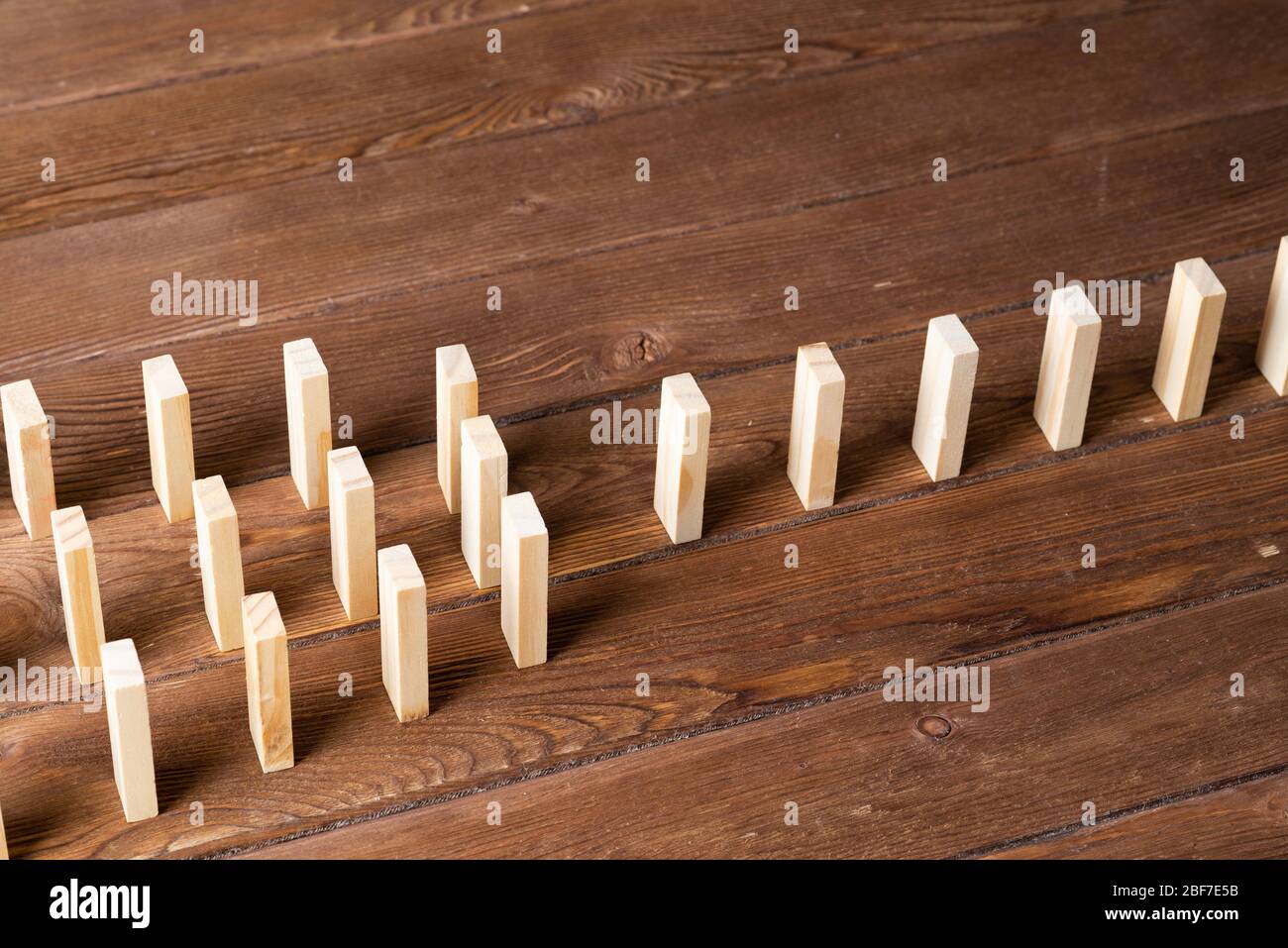 File di domino in piedi su tavolo di legno Foto stock - Alamy