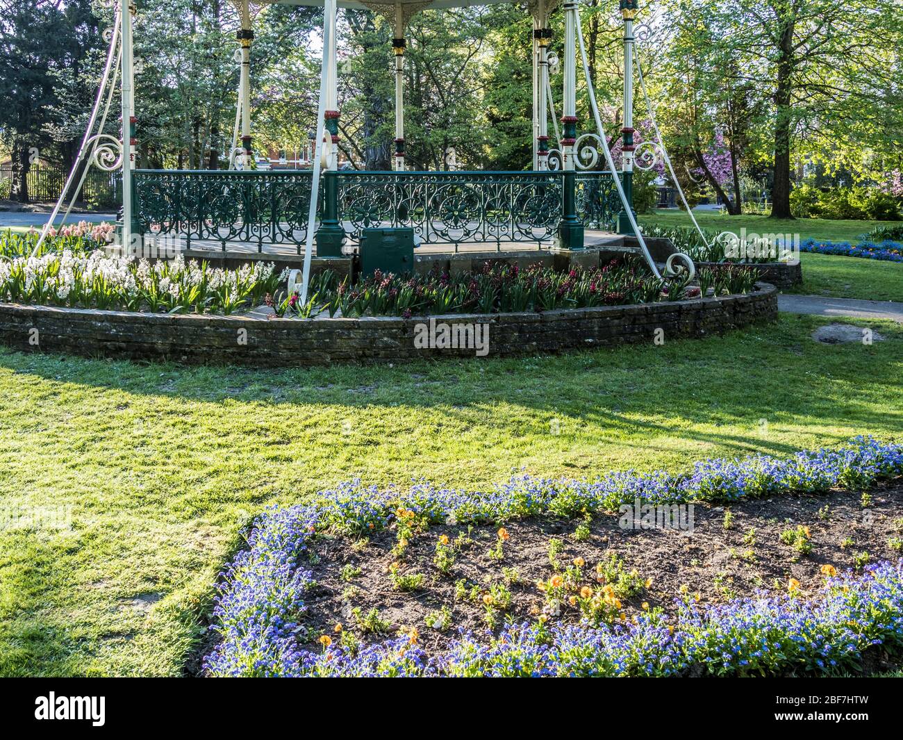 Un palco vittoriano e biancheria da letto primavera in un parco pubblico nel Regno Unito. Foto Stock