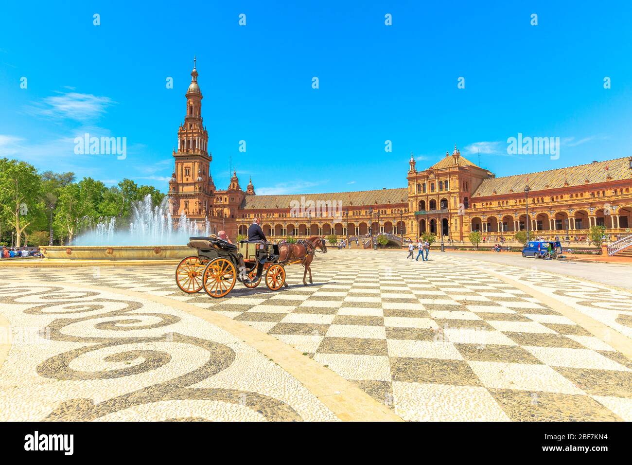 Siviglia, Andalusia, Spagna - 18 aprile 2016: Giro in carrozza a cavallo in Plaza de Espana con torre nord, edificio con colonne e archi e centrale Foto Stock