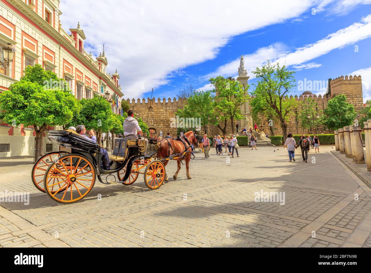 Siviglia, Andalusia, Spagna - 18 aprile 2016: Turisti che fanno un giro in carrozza a cavallo in Piazza Trionfo o Plaza del Triunfo accanto all'Archivio del Foto Stock