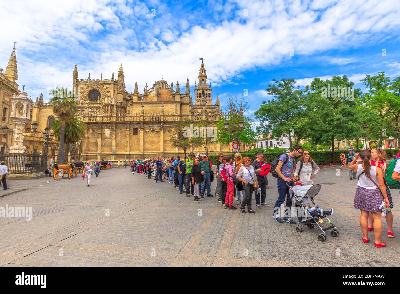 Siviglia, Andalusia, Spagna - 19 aprile 2016: Fila di turisti per visitare il reale Alcazar di Siviglia in piazza Trionfo o plaza del triunfo con Siviglia Foto Stock