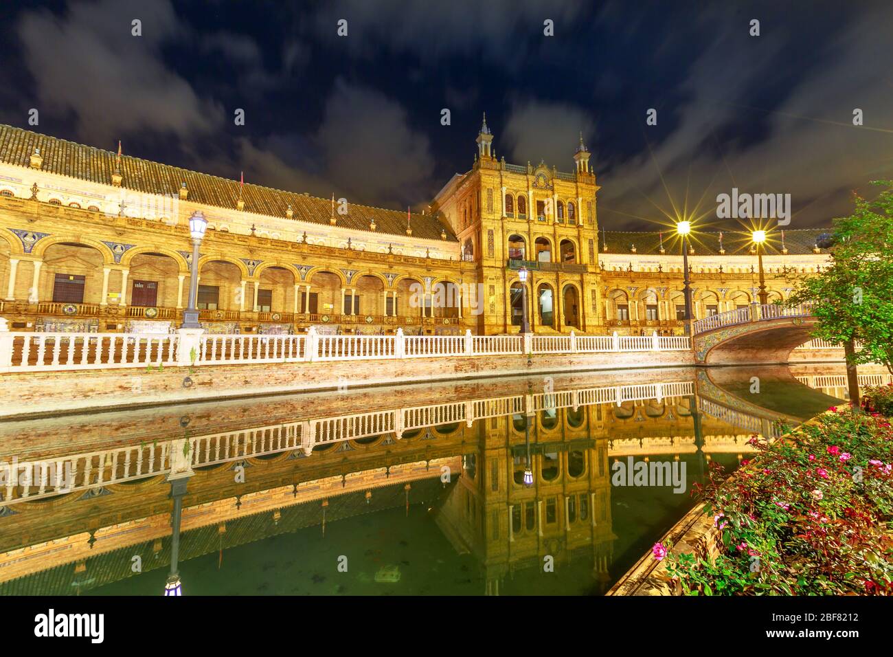 Edificio rinascimentale in Plaza de Espana si riflette sul canale del fiume Guadalquivir a Siviglia. Panoramica Piazza Spagna in Andalusia, Spagna, illuminato a. Foto Stock