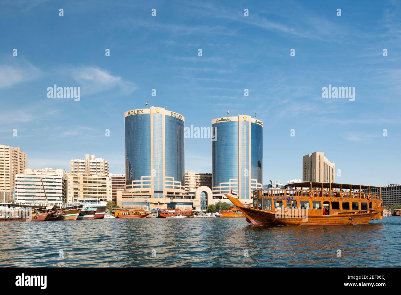 Dhow passando per le Torri Gemelle Deira sul Dubai Creek, Dubai, Emirati Arabi Uniti Foto Stock