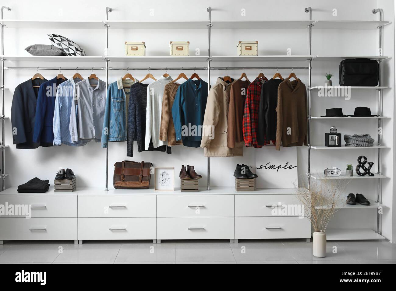 armadio moderno con eleganti abiti invernali e accessori Foto Stock