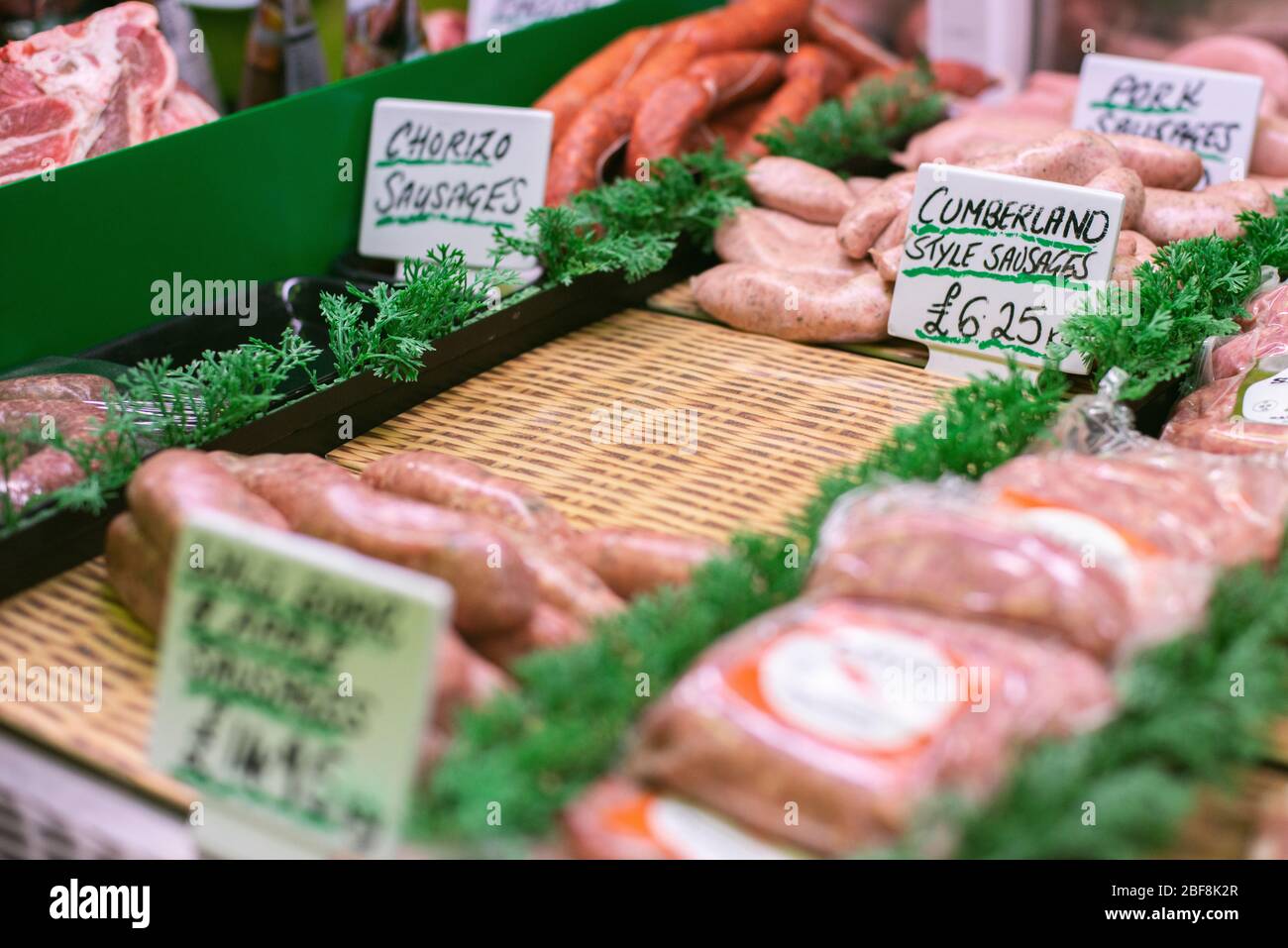 Una gamma di salsicce esposte in un macellaio, realizzate con carne ad alto benessere Foto Stock