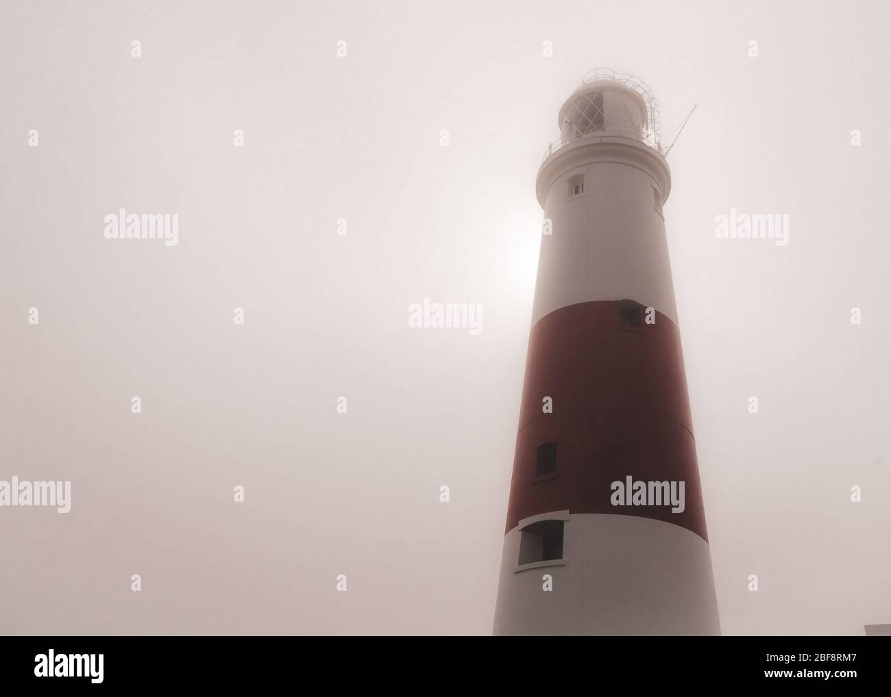 Il faro di Portland Bill in una mattinata d'estate foggy mentre il sole cerca di rompere attraverso dietro, Portland, Dorset, Regno Unito Foto Stock