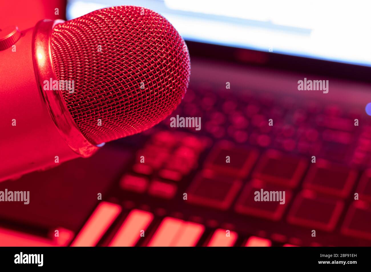 Home Studio con microfono professionale a condensatore e tastiera a piano.  Notebook con luce rossa Foto stock - Alamy