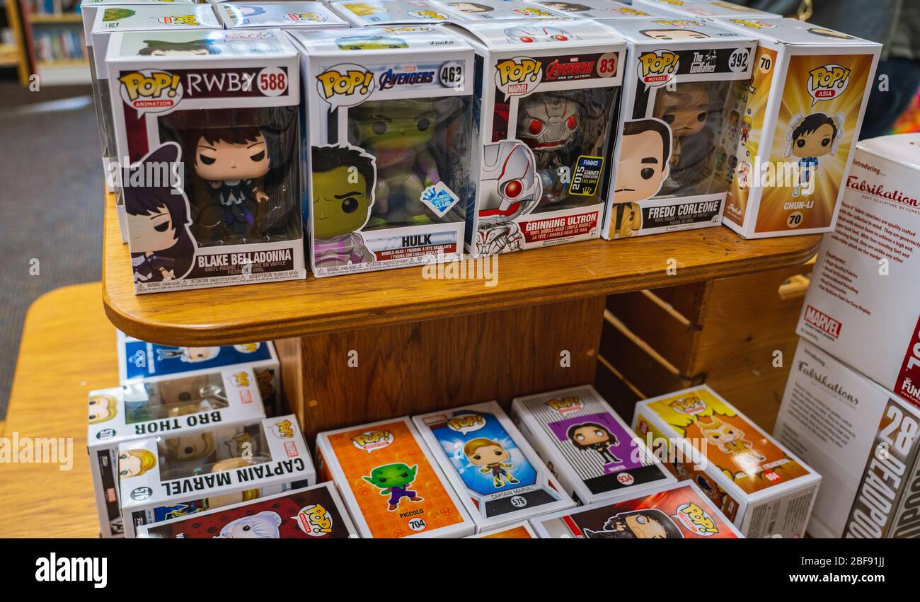 Un tavolo organizzato con una pila di giocattoli Funko Pop in un negozio. Foto Stock