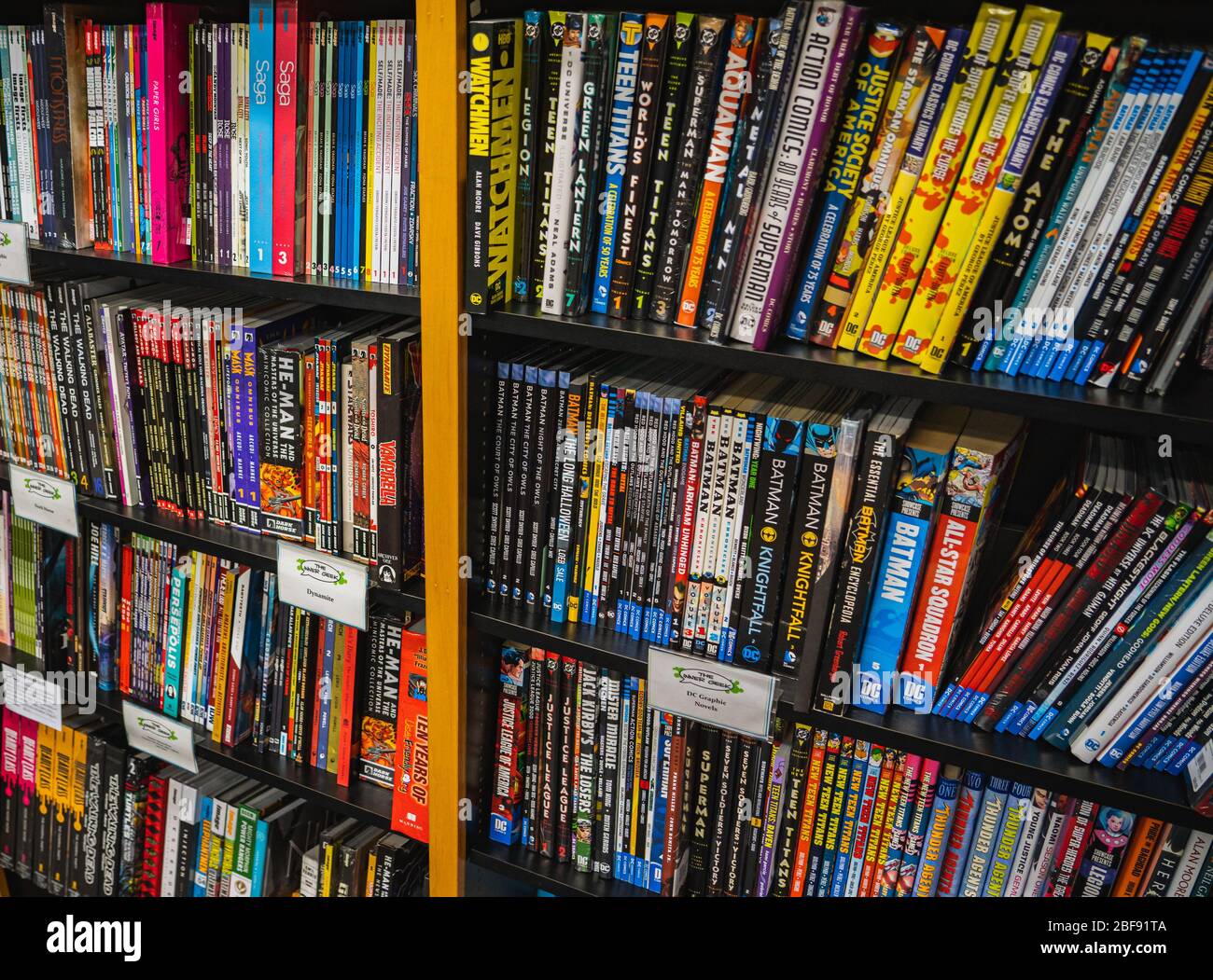 Uno scaffale con romanzi grafici supereroi in un negozio di fumetti. Foto Stock
