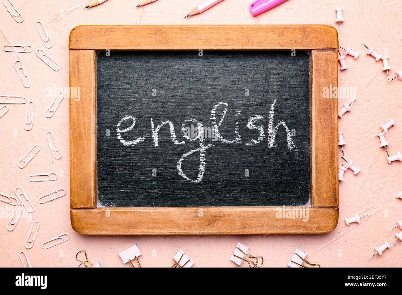Lavagna con testo INGLESE e cancelleria su sfondo a colori Foto Stock