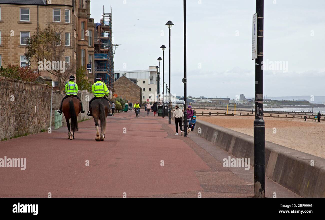 Portobello, Edimburgo, Scozia, Regno Unito. 17 aprile 2020. Amichevole uomini e donne ufficiali di polizia montato pattuglia la tranquilla passeggiata lungomare su controllo di routine, ma buona excercise per cavalli Coupér e Oban in un pomeriggio asciutto, nuvoloso con temperatura di 9 gradi. Durante la settimana è stato riferito che la polizia locale era soddisfatta di come il pubblico aveva risposto al Coronavirus Lockdown e non si riuniva in grandi gruppi sulla spiaggia o Promenade. Credit: Arch White/Alamy Live News. Foto Stock