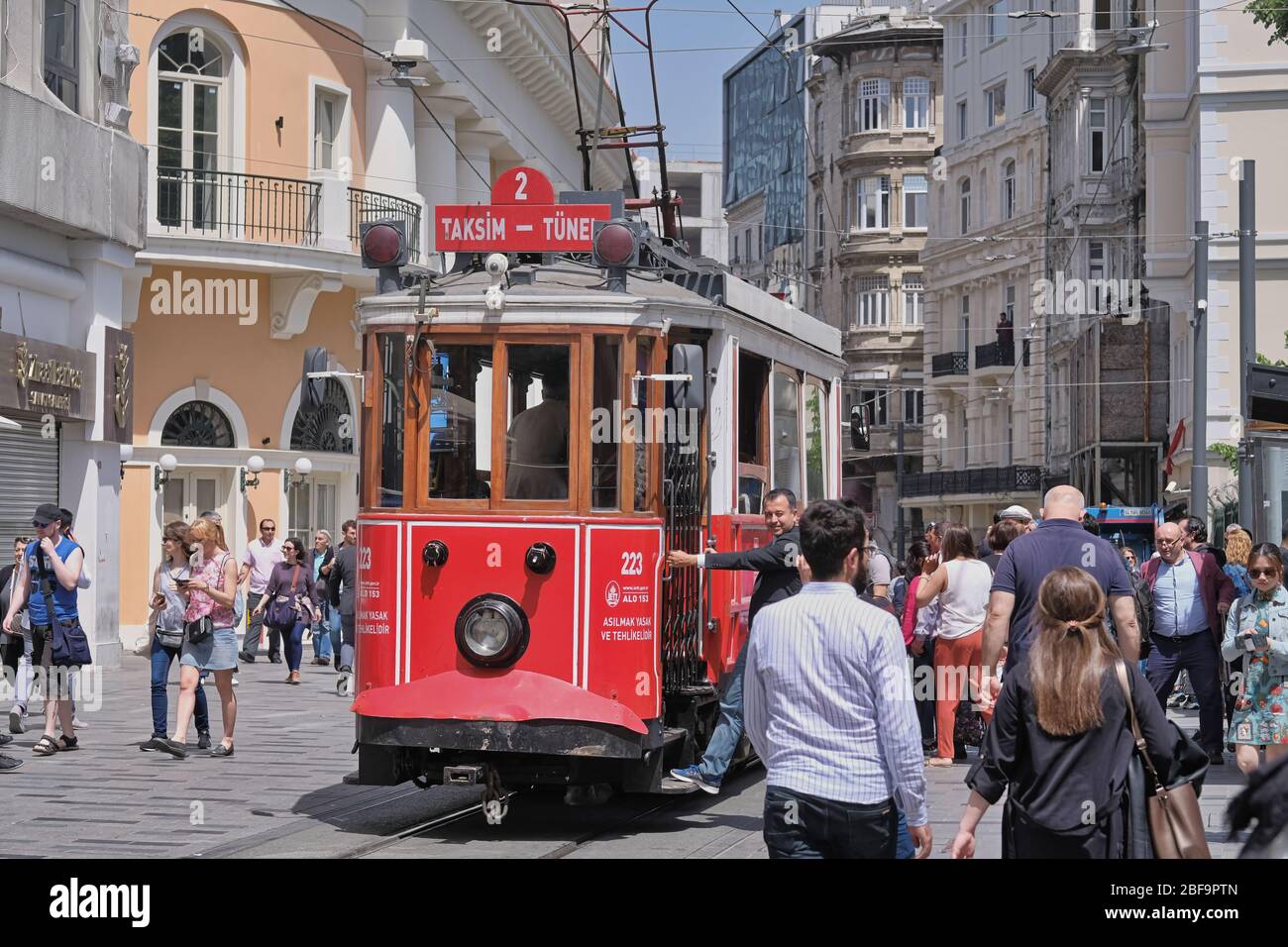 Il nostalgico tram rosso in via Taksim Istiklal a mezzogiorno. Taksim Istiklal Street è una destinazione popolare a Istanbul. Beyoglu, Taksim, Istanbul. Turchia. Foto Stock