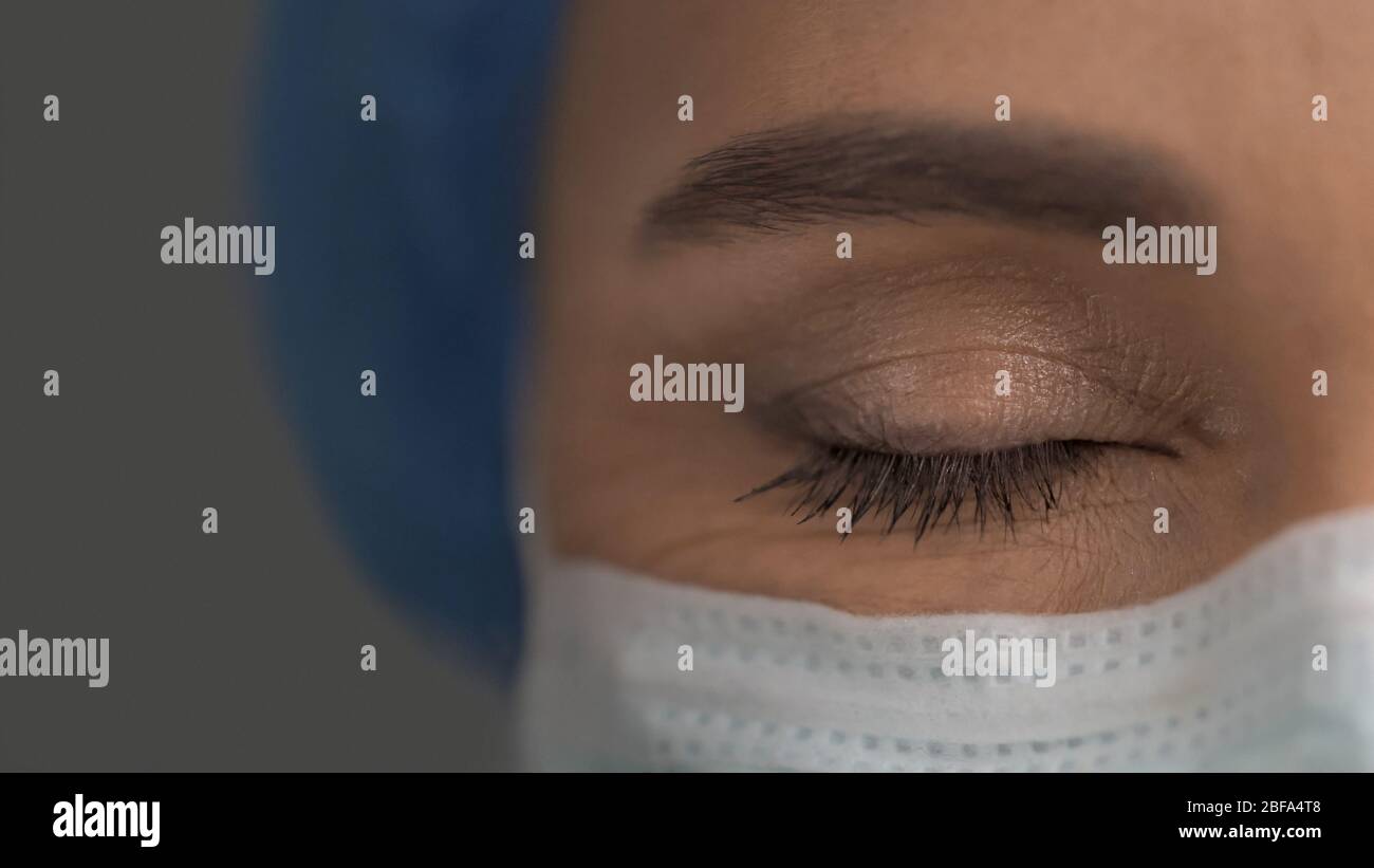 Occhio chiuso del medico femminile in maschera protettiva, primo piano Foto Stock