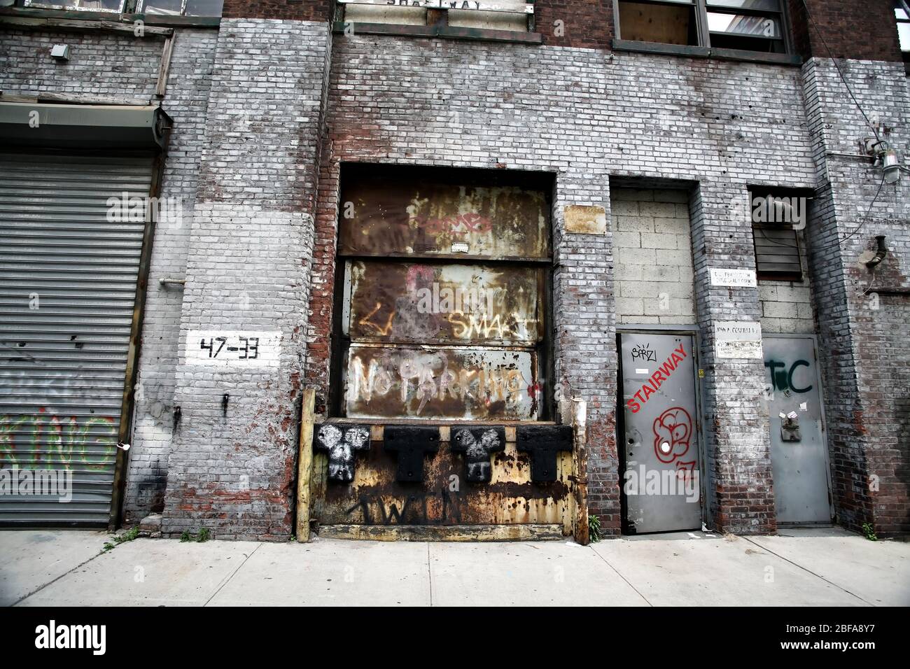 Muro di edificio industriale con grate a rullo a New York City, NY, USA Foto Stock