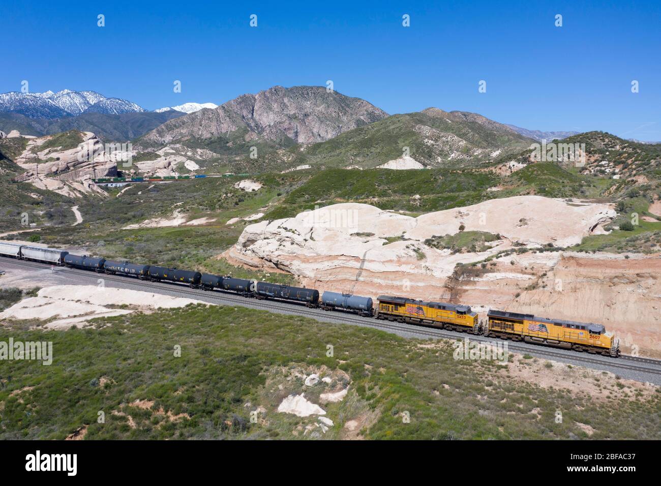 Treno merci che sale al Cajon Pass nella contea di San Bernardino, parte della grande catena logistica della California meridionale Foto Stock