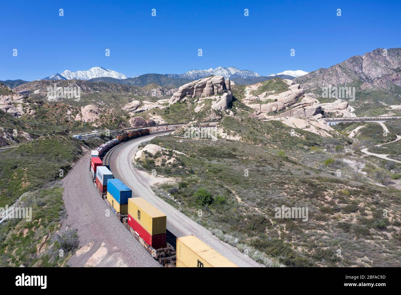 Treno merci che sale al Cajon Pass nella contea di San Bernardino, parte della grande catena logistica della California meridionale Foto Stock