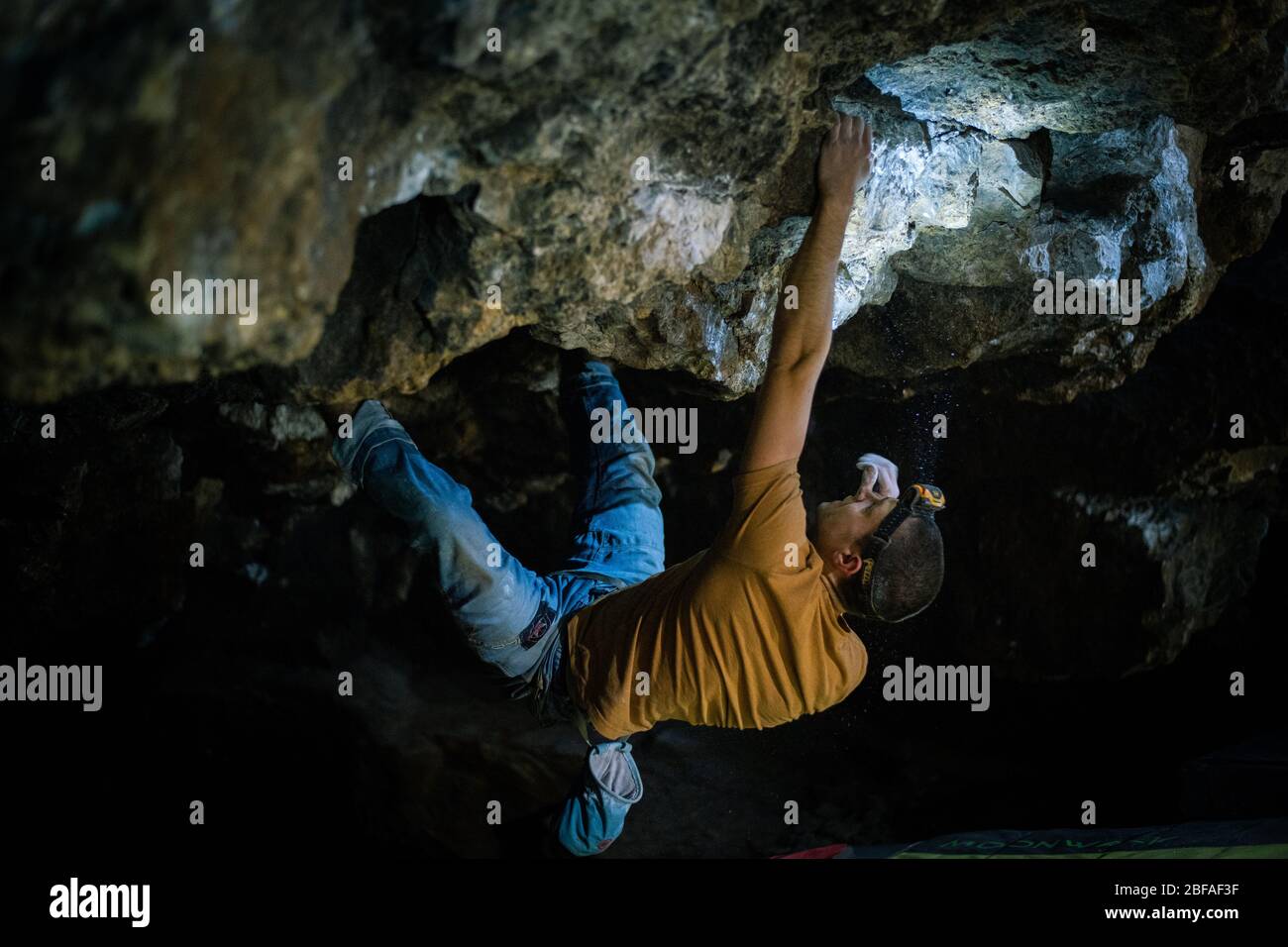 KRAKÓW, POLONIA – 02,02,2020: L'uomo sta facendo un masso nella grotta di Twardowski. Bouldering nella roccia. Grotta di Twardowski Foto Stock