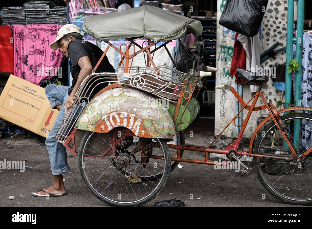 Pilota e il suo ciclo risciò a Yogyakarta, Java, Indonesia Foto Stock