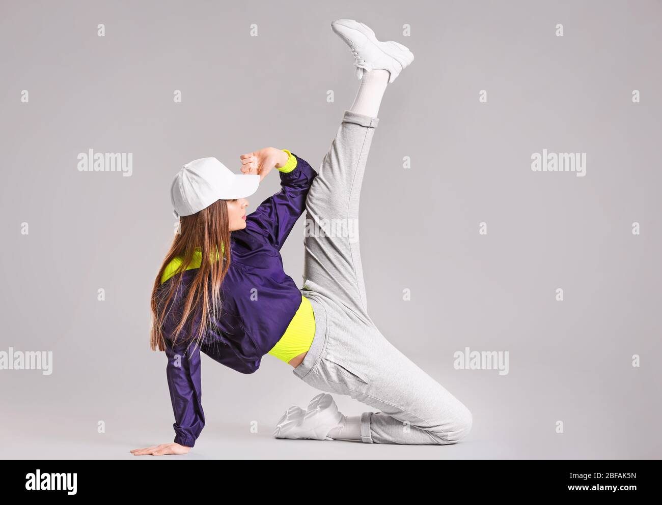 Giovane ballerina hip-hop femminile su sfondo grigio Foto stock - Alamy