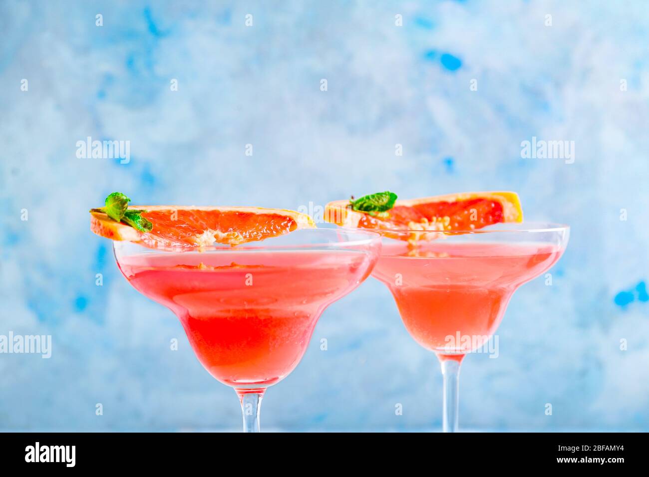 Bicchieri di gustoso cocktail mimosa su sfondo colorato Foto Stock