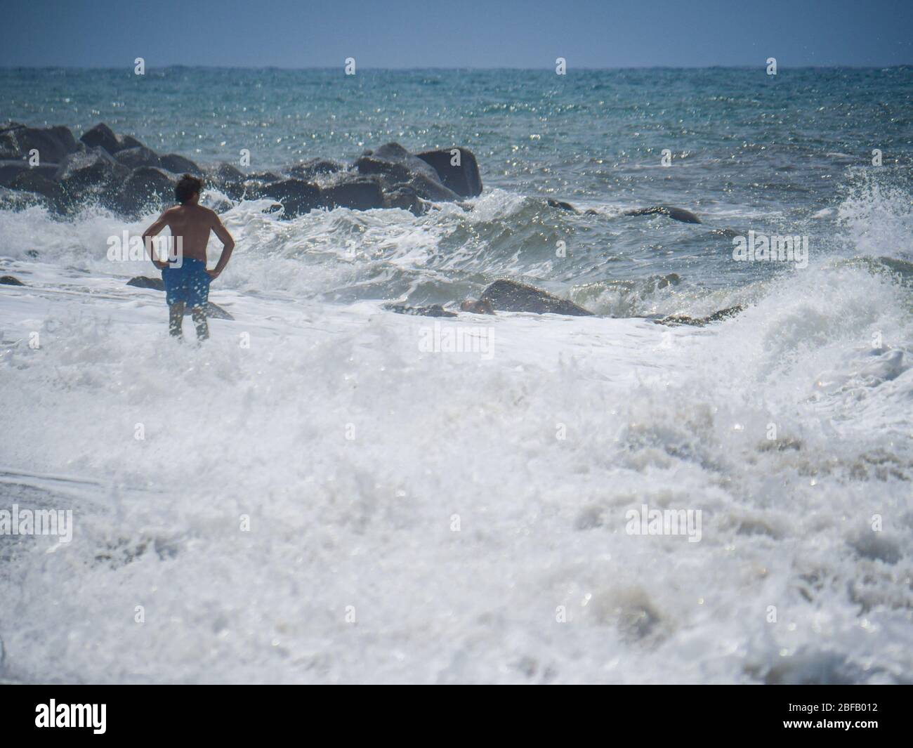 Bagnatevi sulla spiaggia durante una tempesta pesante. Onde che si infrangono potentemente sulla riva. Foto Stock