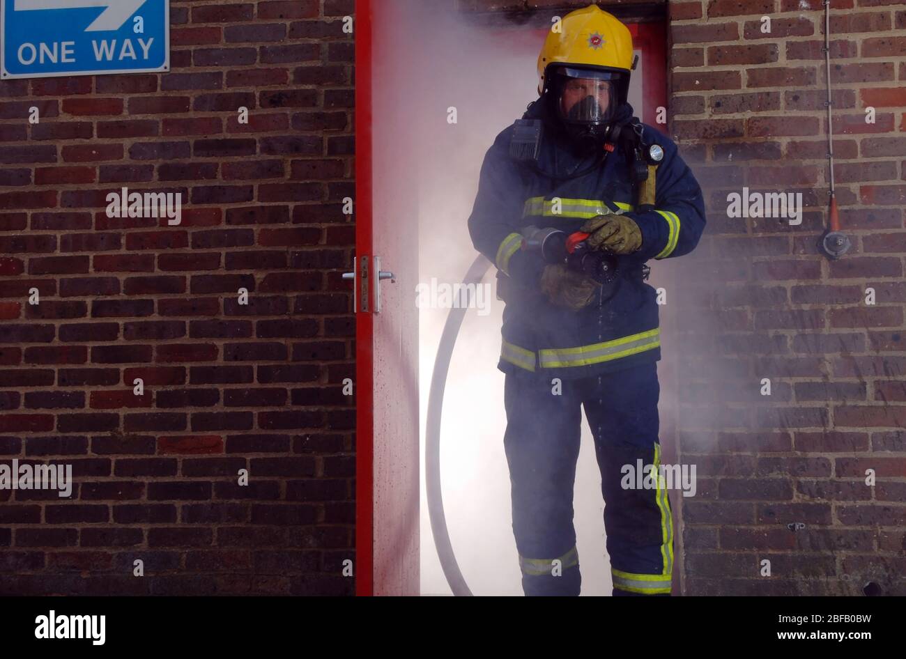 Indossare un apparecchio di respirazione completo, un vigile del fuoco, da Hertfordshire Fire & Rescue Service lasciando un edificio pieno di fumo. Nel dicembre 2005, HFRS dea Foto Stock