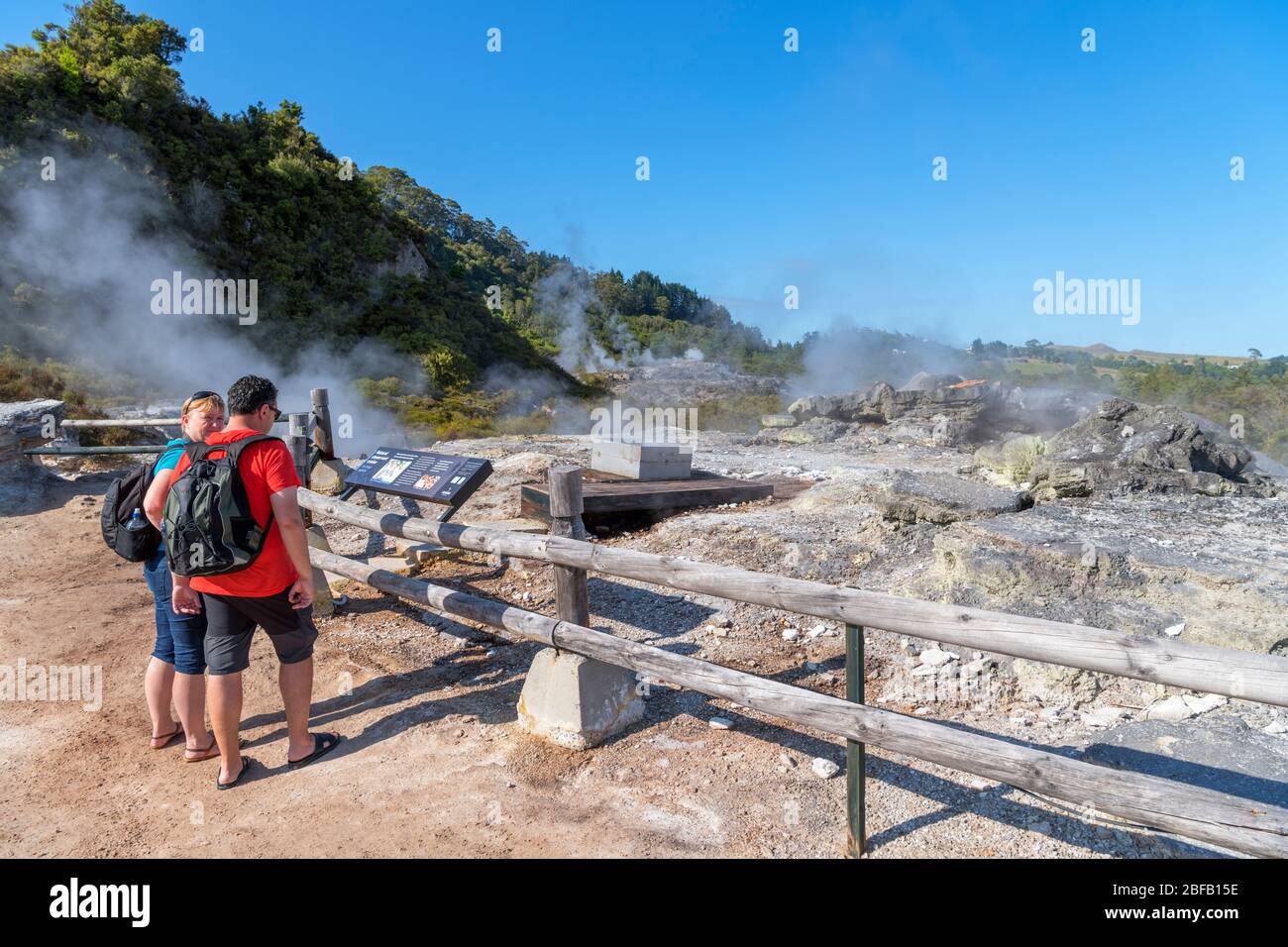Coppia che guarda il fornello naturale di sfiato del vapore (Hangi ngawha), te Puia, te Whakarewarewa Geothermal Valley, Rotorua, Nuova Zelanda Foto Stock